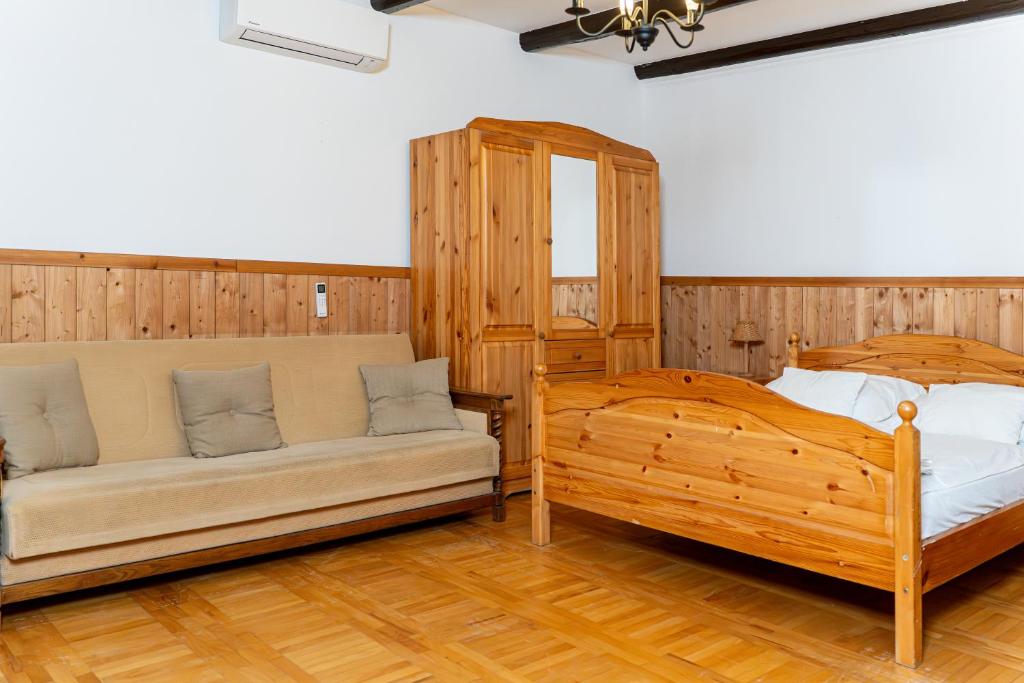 Tágas apartman kanapéval és fa franciaággyal